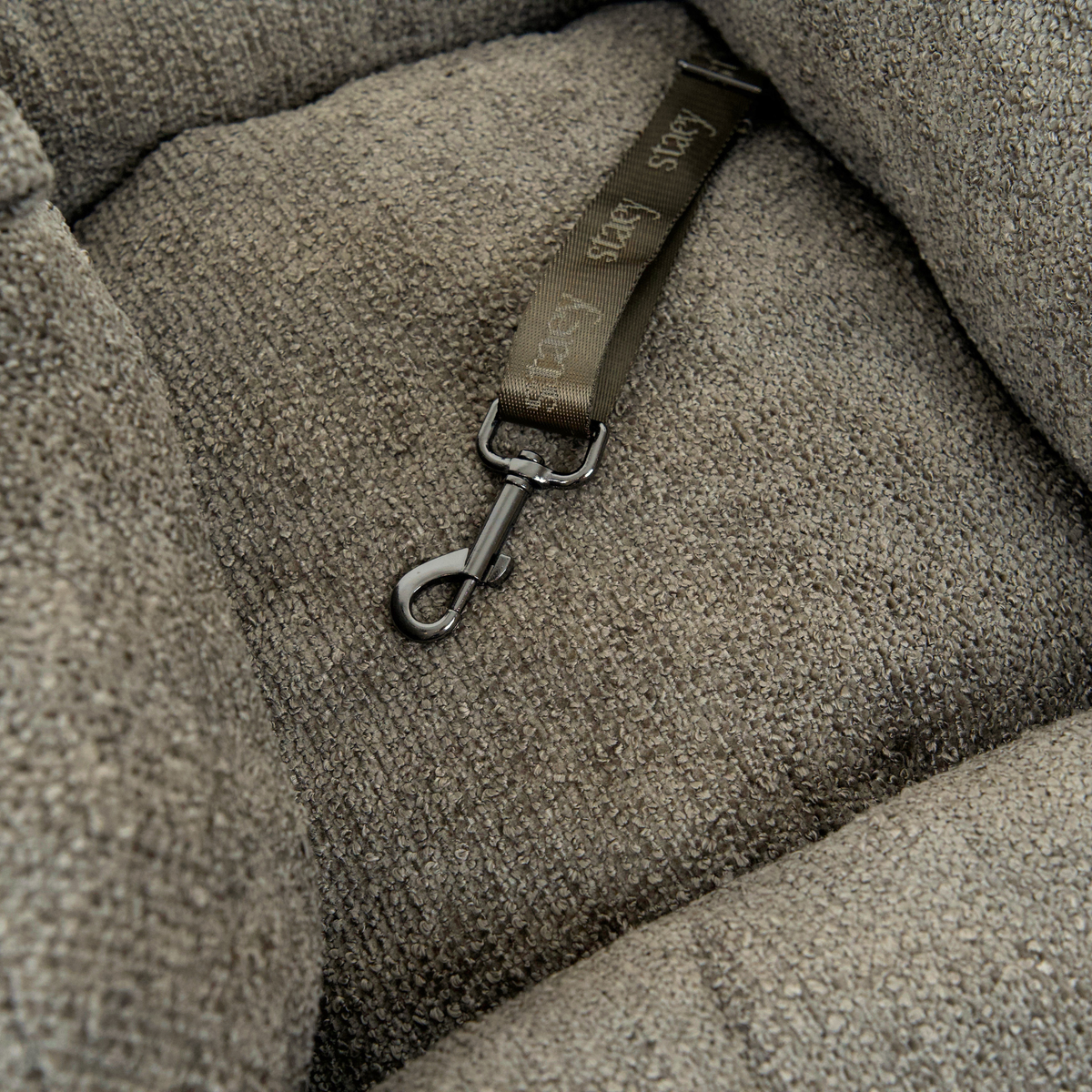 Close-up of the safety leash inside a taupe bouclé dog car seat