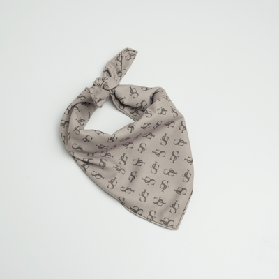 The ST bandana knotted and laid flat, showing its monogram print