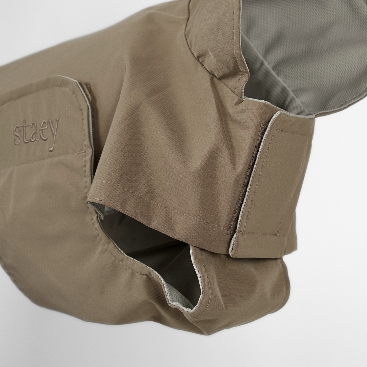 Close-up of the taupe rain coat collar and its grey lining