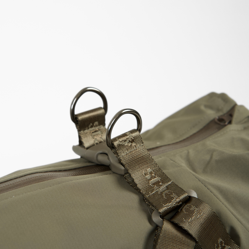 Close-up of the D-rings and harness buckle on the moss green rain coat