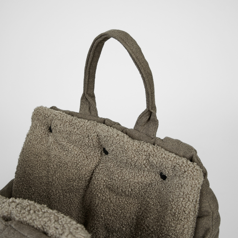 The olive teddy carrier bag seen from above with its handles